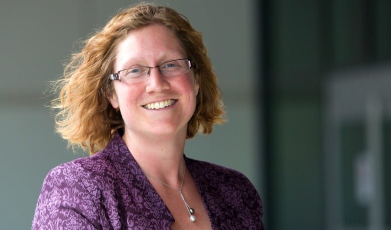 A woman smiles at the camera.