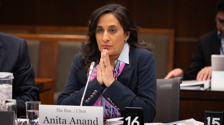 A politician sits at a desk before a committee meeting.