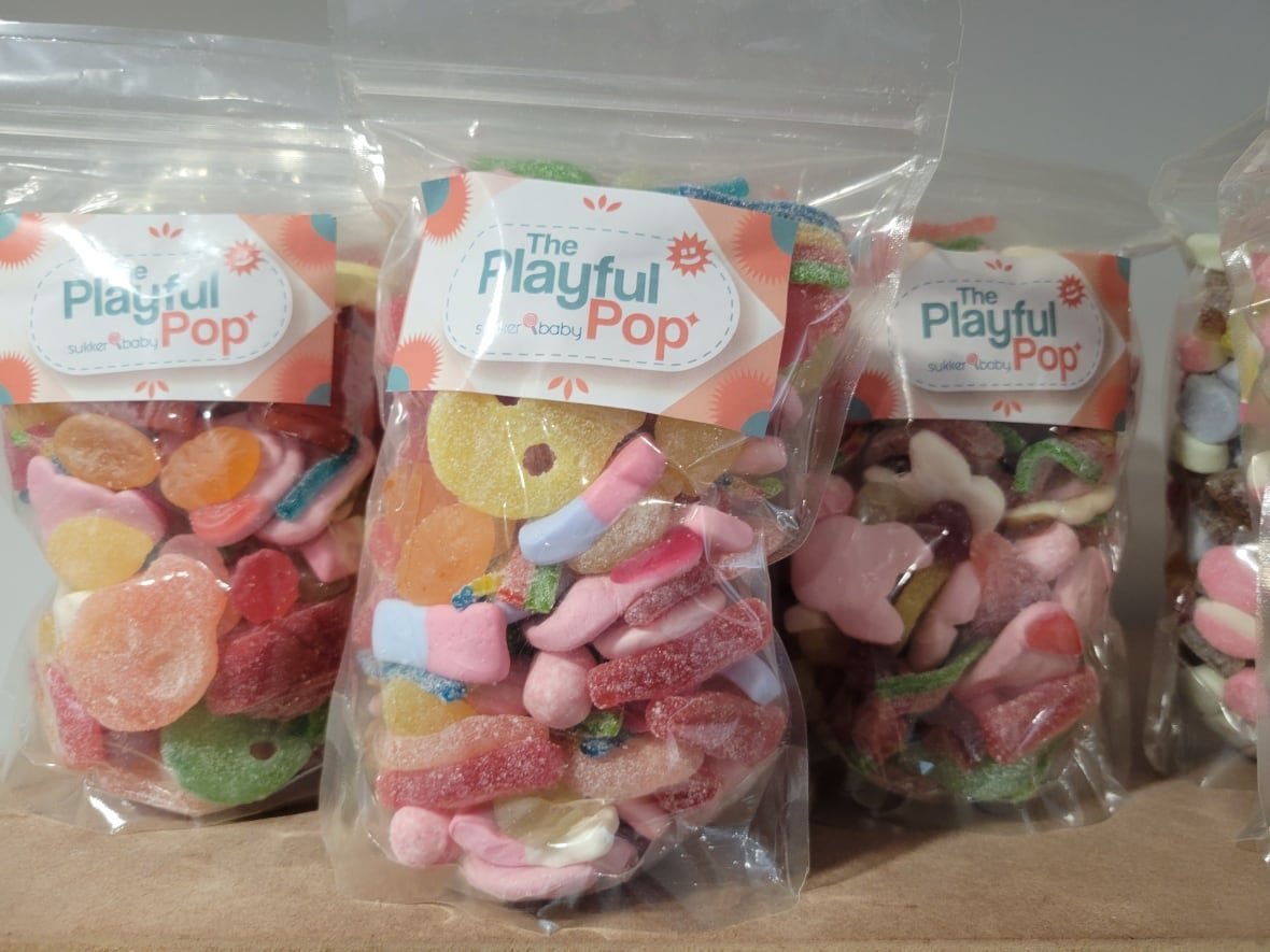 Several bags of assorted candy are shown bearing the label 'The Playful Pop'.