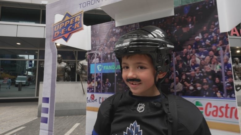 Grayson Haire, 7, is interviewed by a CBC Toronto reporter outside of Scotiabank Arena in Toronto on Monday.