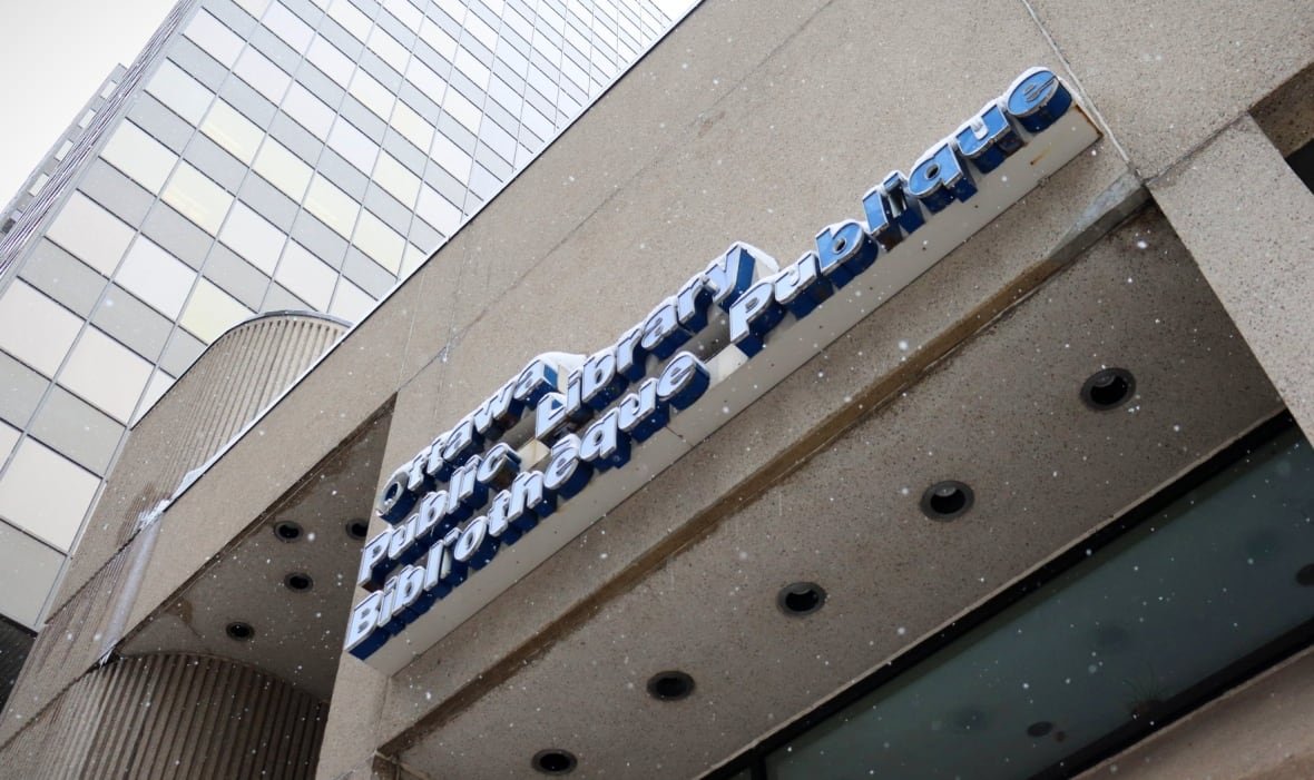 A blue library sign attached to a concrete building.