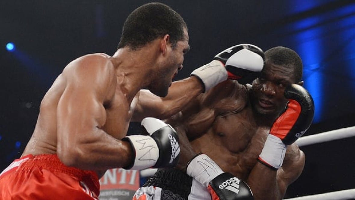 Troy Ross of Canada absorbs a punch from Cuba's Yoan Pablo Hernandez during their IBF cruiserweight world title bout in Germany on Sept. 15, 2012.