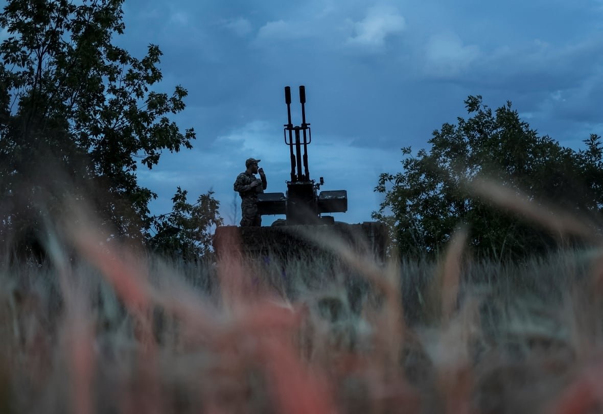 A Ukrainian soldier watches for incoming Russian drones, in the Kherson region, in June 2024.