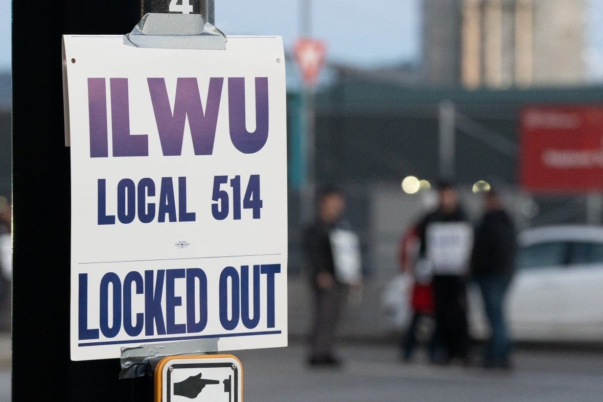 A sign reads 'ILWU Local 514 Locked Out' on a traffic post.