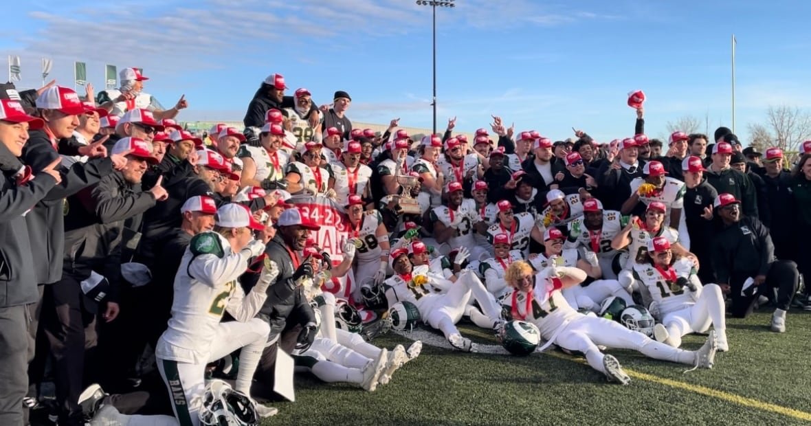 Football players surround a trophy.