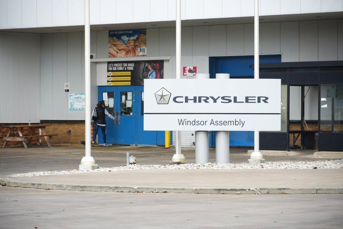 Worker shown opening a door at Stellantis' Windsor assembly plant.